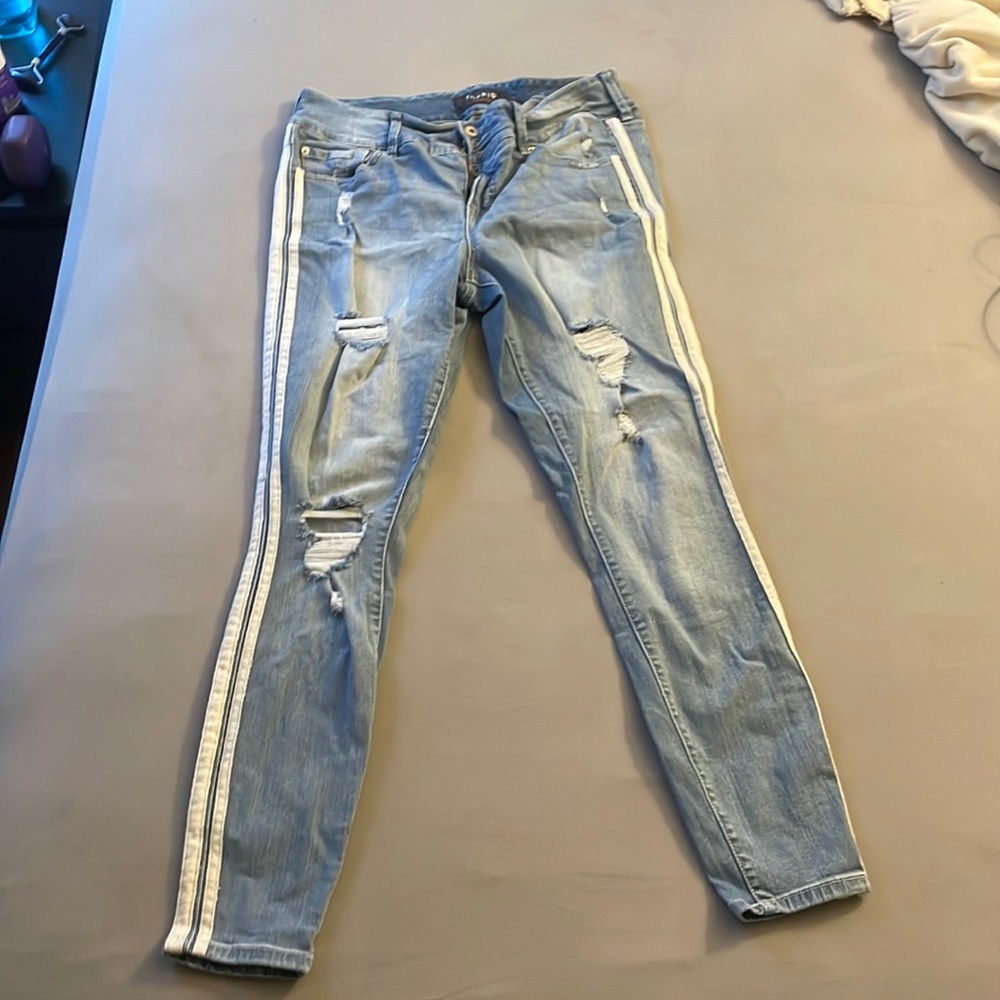Ripped skinny jeans. Light blue wash. Has white racing stripes down each side.